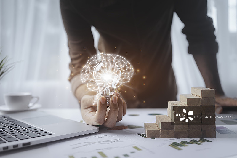 男人手拿灯泡，为更好的工作设计寻找新思路图片素材