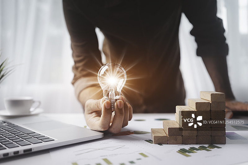 男人拿着灯泡寻找更好的工作设计新思路图片素材