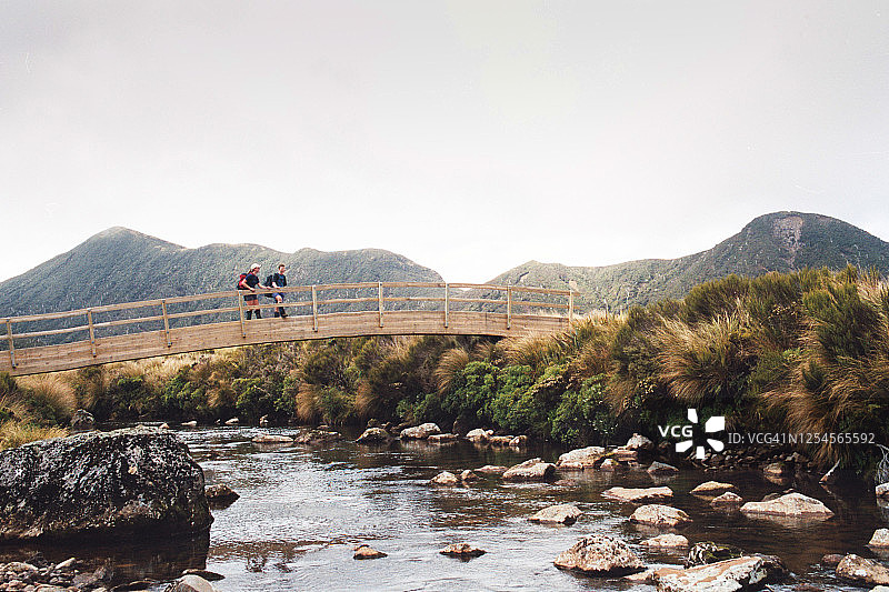 徒步者站在塔拉纳基埃格蒙特山木桥上图片素材