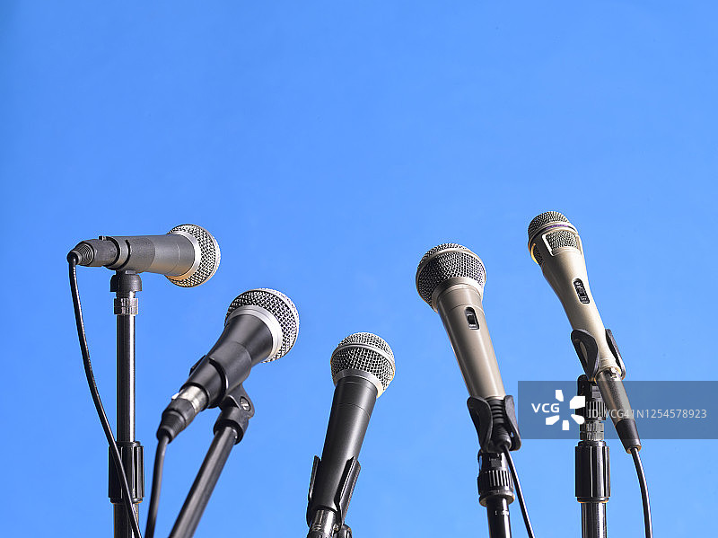 蓝色背景上为新闻发布会设置的麦克风图片素材