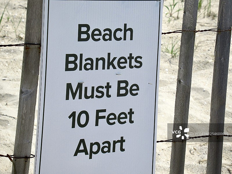 社交距离：冠状病毒大流行期间海滩的信息标志图片素材