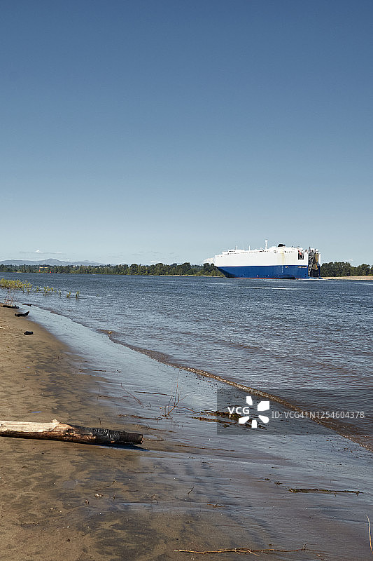 从索维岛看哥伦比亚河上行驶的大型运输车，背景是圣海伦斯山图片素材