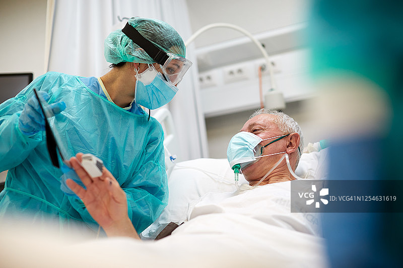 护士向新冠患者展示亲属照片图片素材