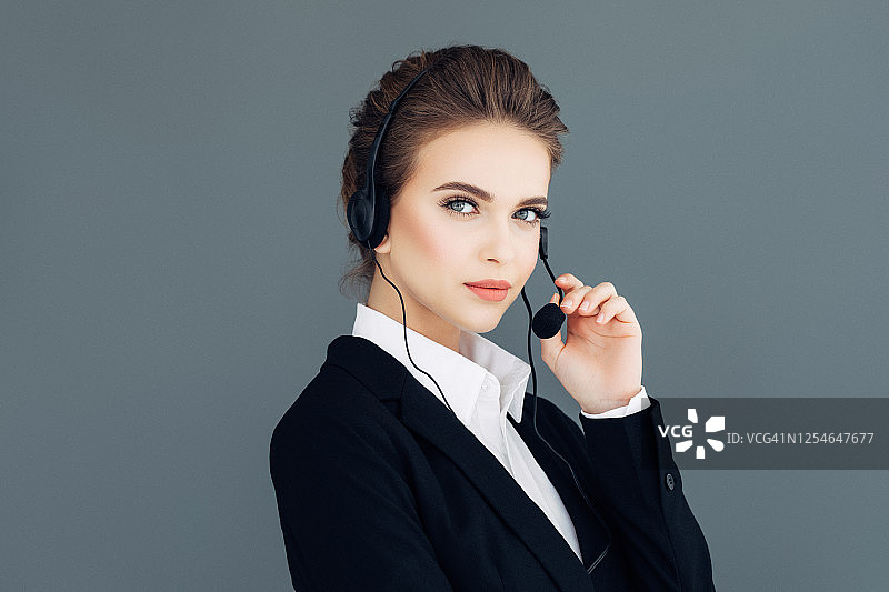 佩戴耳机的微笑职业女性图片素材