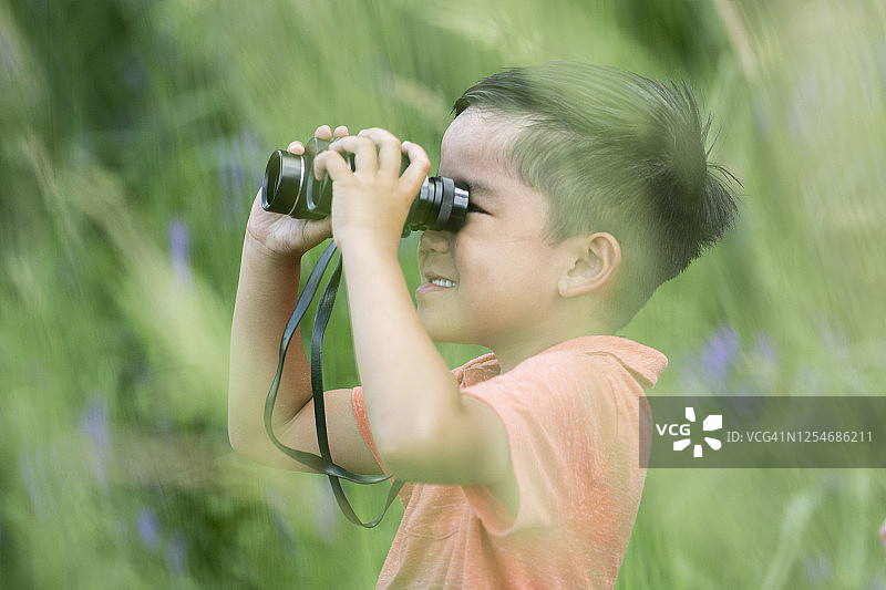使用双筒望远镜探索的男孩图片素材