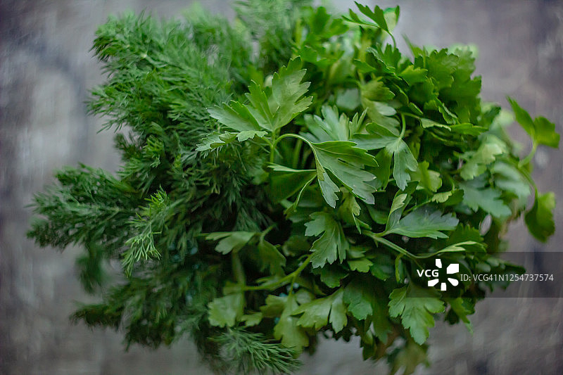 深色旧木背景上的绿色香草莳萝和欧芹图片素材