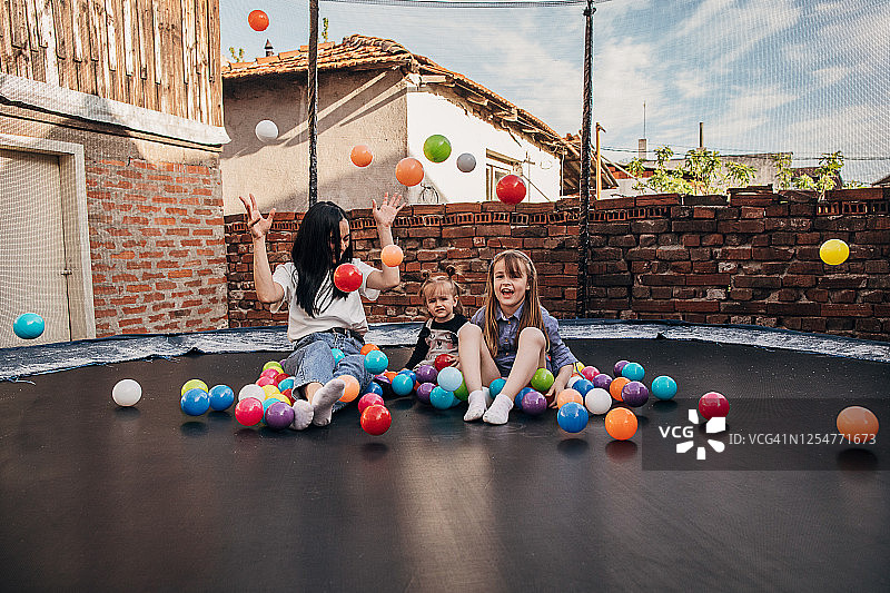 母亲和女儿在蹦床上玩耍图片素材