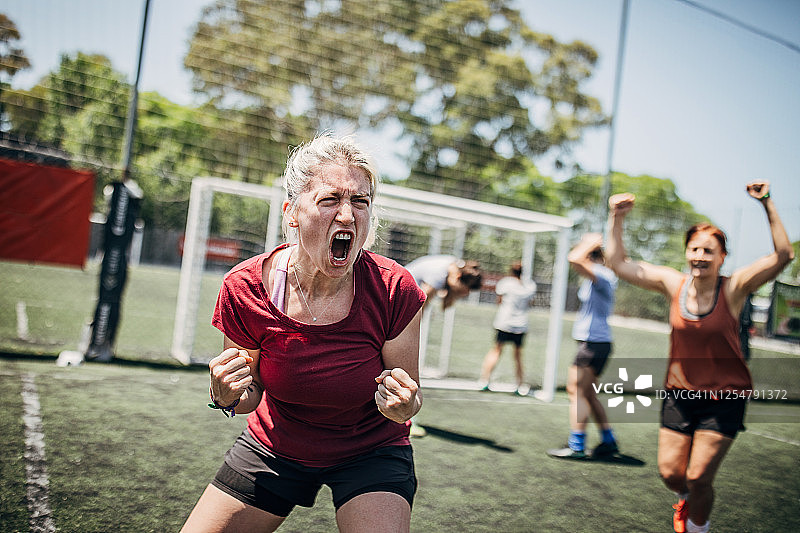 女足球员在足球场上庆祝胜利图片素材