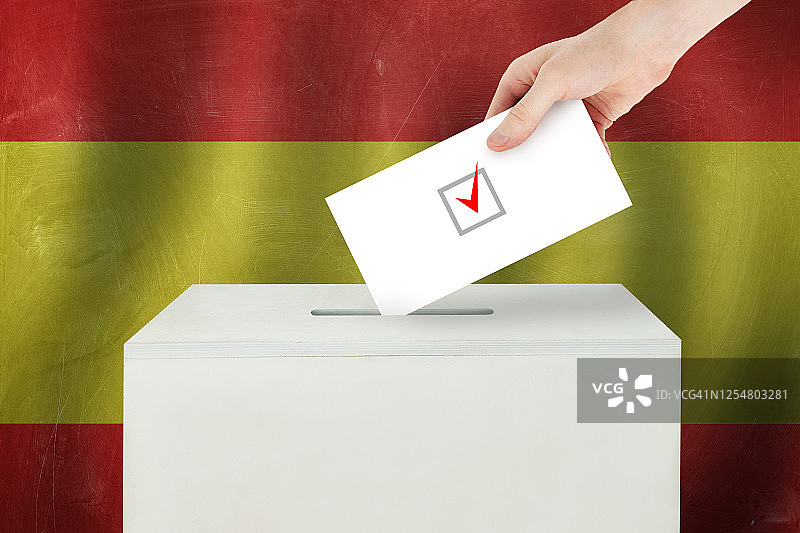 西班牙投票概念。选民手持选票在投票站进行选举投票图片素材