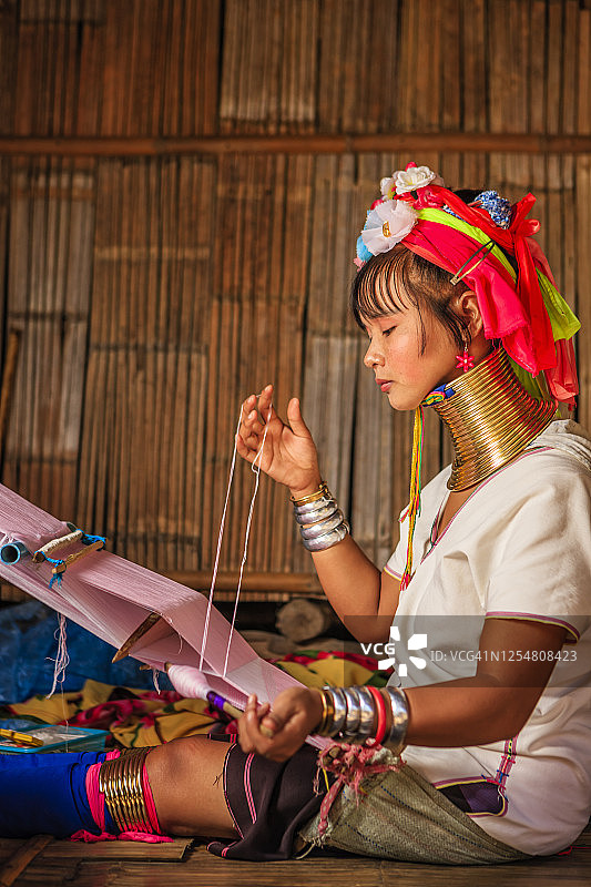 长颈喀伦族年轻女子在传统织布机上编织图片素材