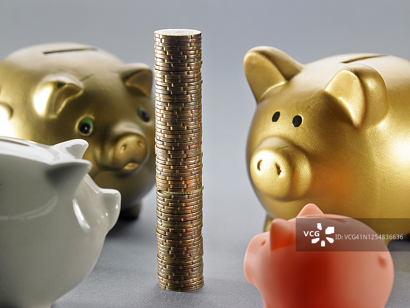 四个小猪存钱罐和硬币图片素材