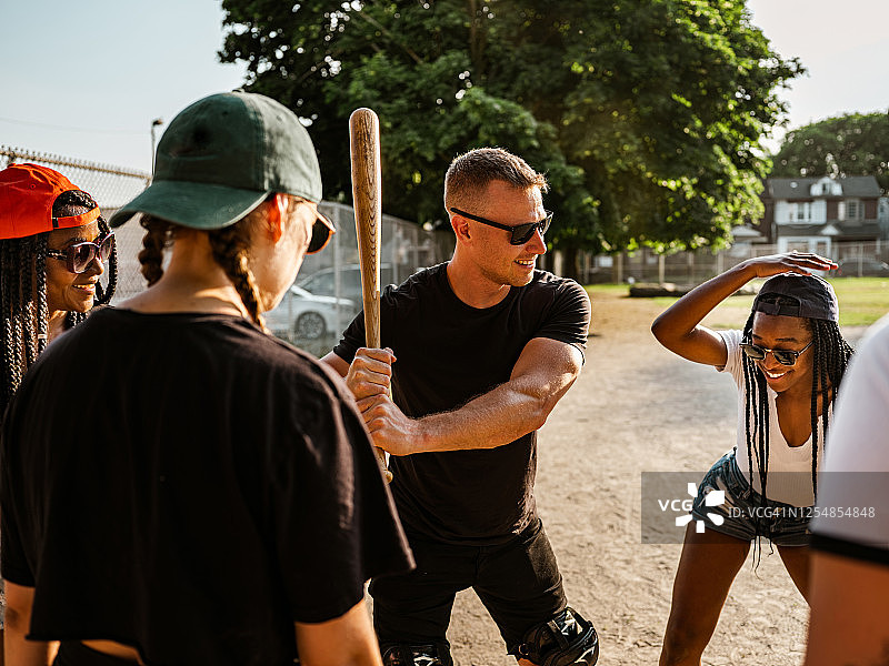 一群 diverse 的年轻人玩垒球图片素材