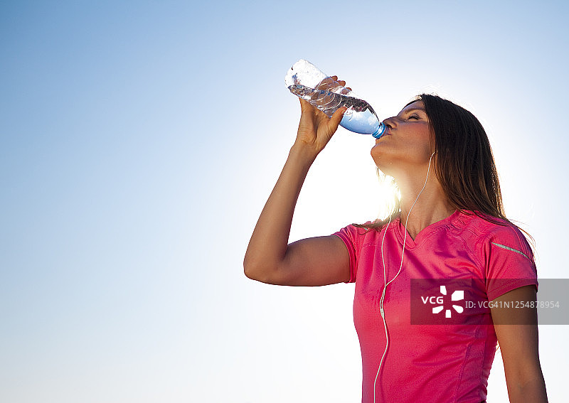 在健身时间喝水和锻炼的年轻女孩图片素材