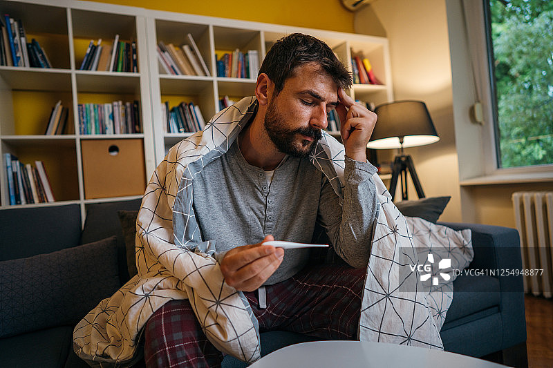 生病的男人正在量体温图片素材