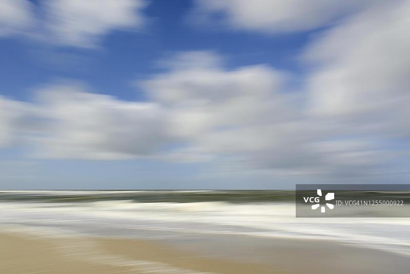 德国石勒苏益格-荷尔斯泰因州叙尔特岛海滩：海浪与多云天空图片素材