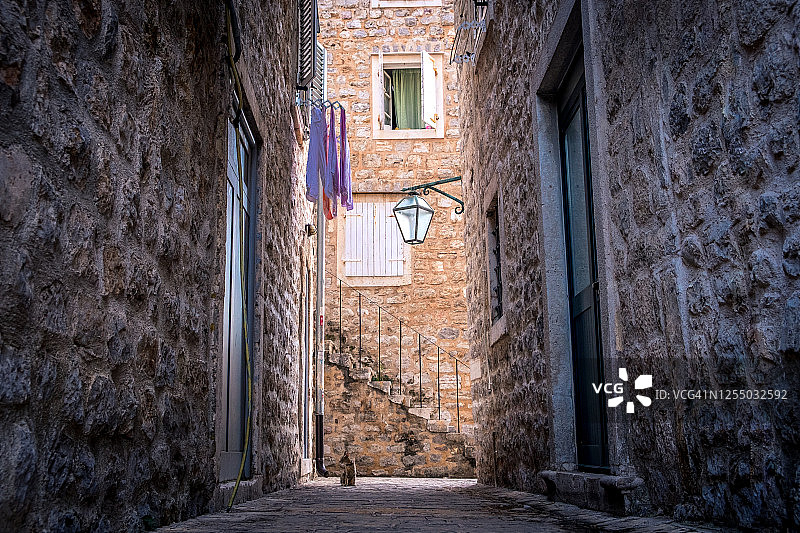 布德瓦老城舒适的庭院：晾晒的衣服和可爱的家猫图片素材