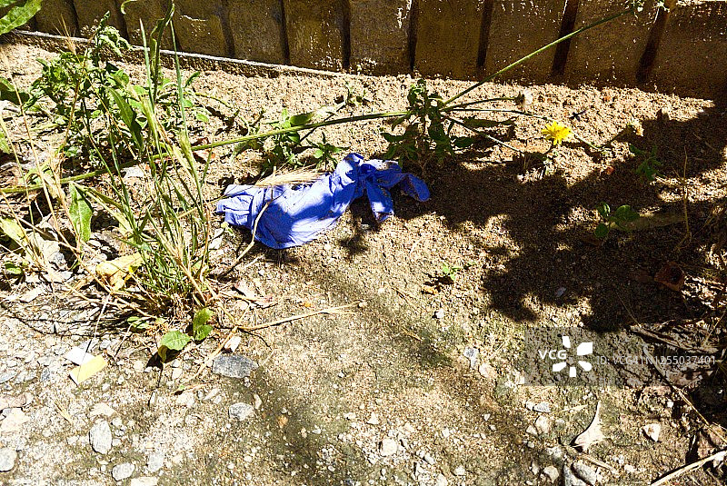用过的口罩和手套乱扔在地上，新冠疫情防护垃圾处理新概念图片素材