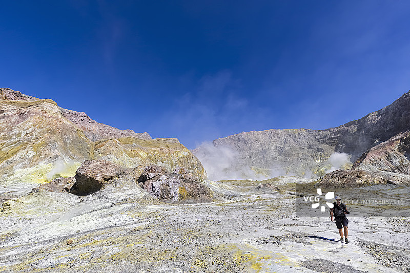 新西兰北岛怀卡塔尼：徒步于怀特岛(瓦卡阿里)的男性背包客图片素材