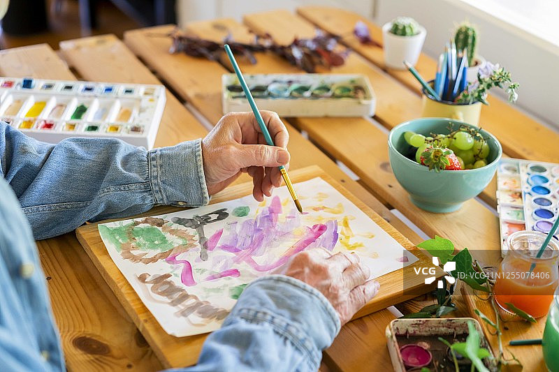 年长的男人在家在纸上绘画图片素材