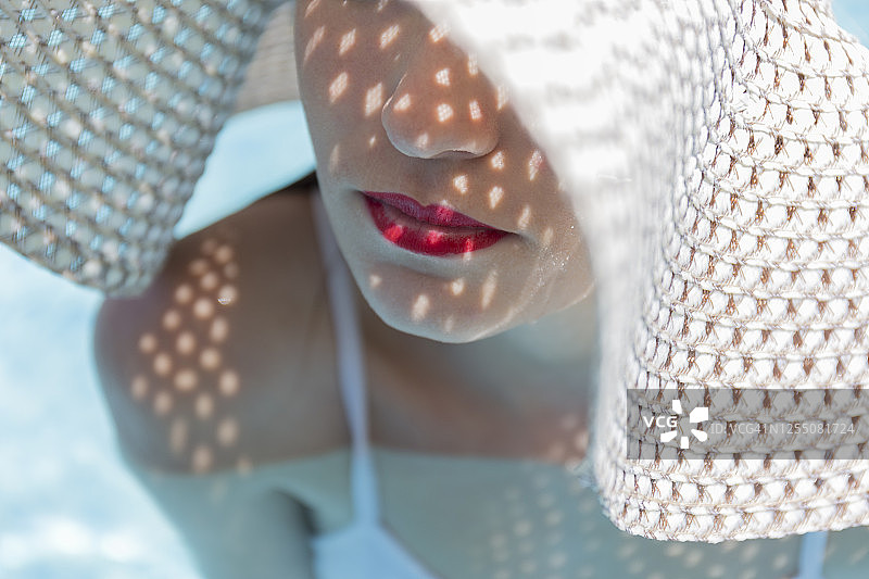 戴帽红唇年轻女子在泳池特写图片素材
