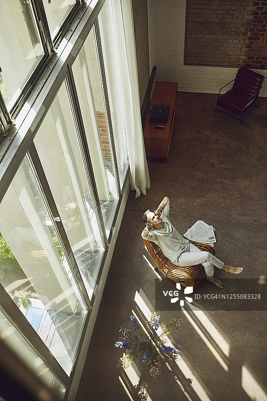 年长男人在LOFT公寓椅子上放松图片素材