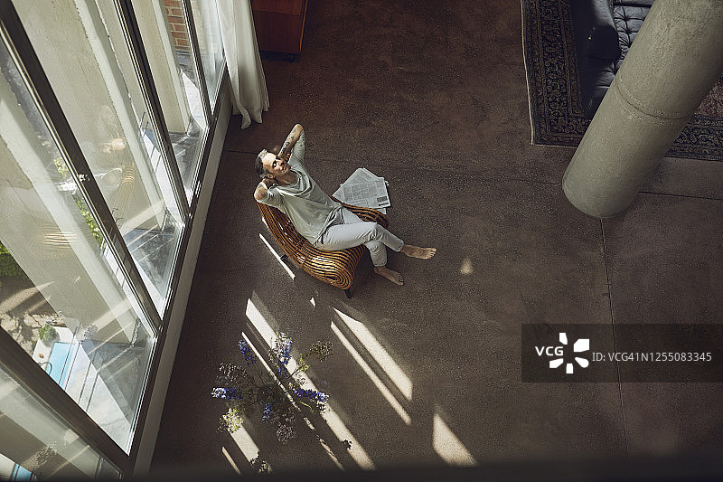 年长男人在LOFT公寓椅子上放松图片素材