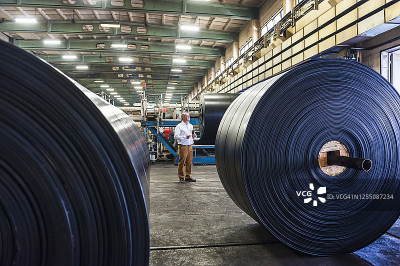 在橡胶加工厂的年长商人图片素材