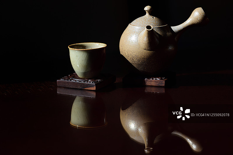 棕色木桌上的日式茶杯和陶制茶壶图片素材