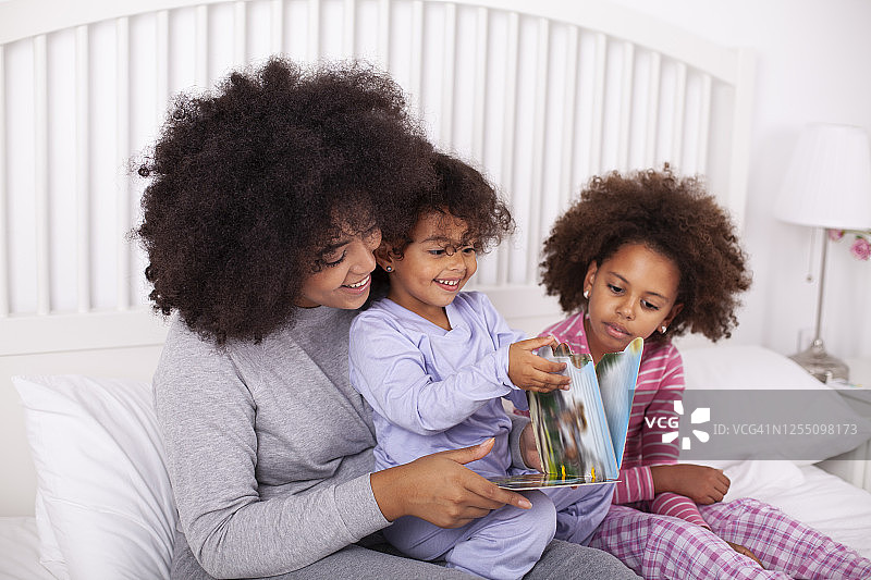 母亲和女儿在床上读书图片素材