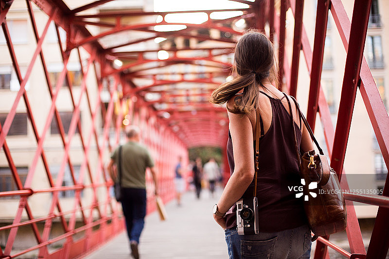 在红色桥上拍照的女游客图片素材