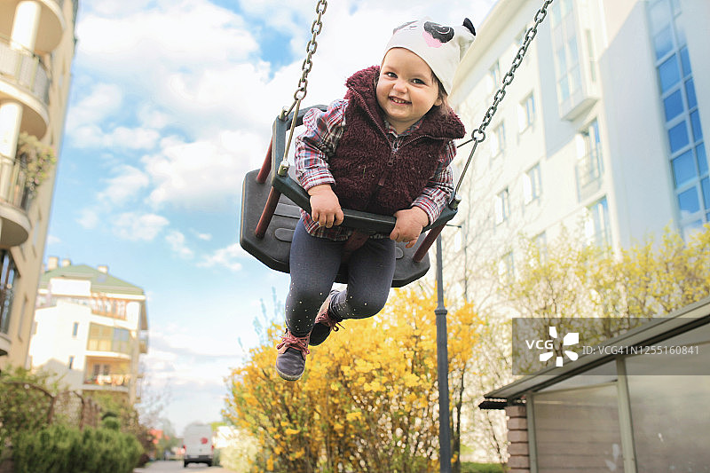 小女孩荡秋千并微笑图片素材
