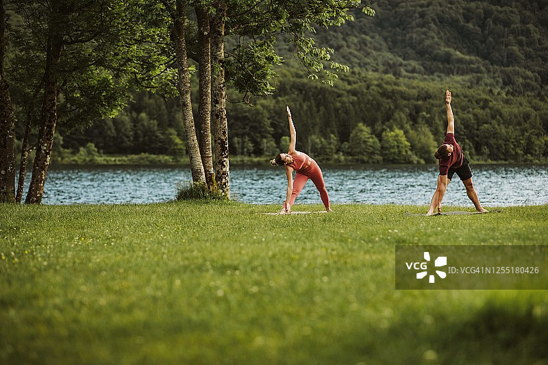 男女在湖边做瑜伽图片素材