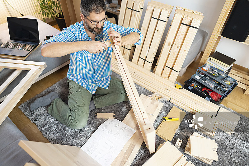 中年男人在家安装室内家具图片素材