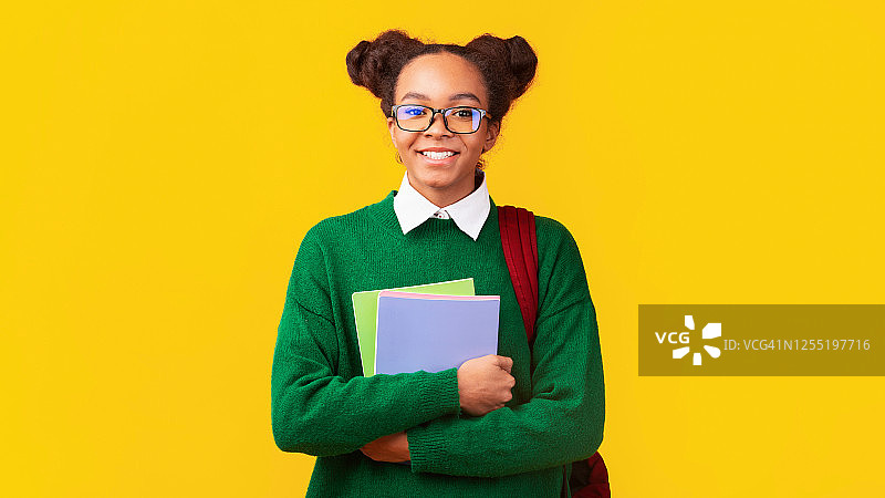 拿着彩色笔记本的非裔美国少女图片素材