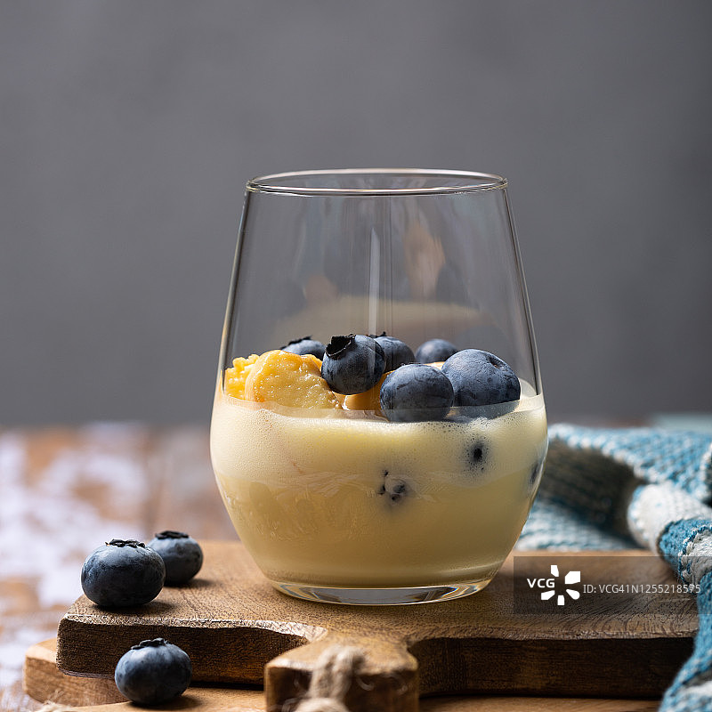 玻璃杯装夏季蓝莓甜点，搭配手指饼干和马斯卡彭奶油，留白图片素材