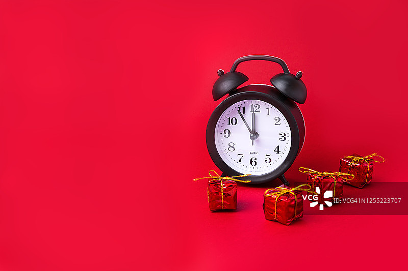 红色背景上的圣诞节闹钟和礼品盒：新年倒计时图片素材