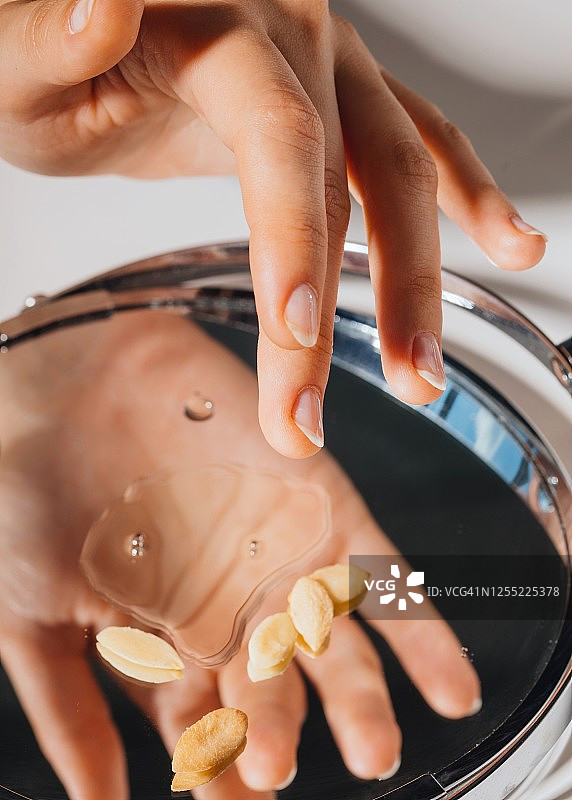 女人用手指蘸取摩洛哥坚果油图片素材