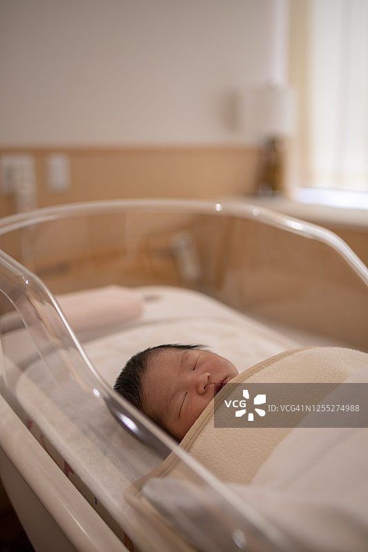 新生婴儿在婴儿床里睡觉图片素材