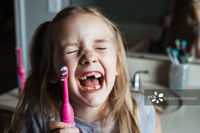 在家刷完牙后咯咯笑的可爱龅牙女孩图片素材