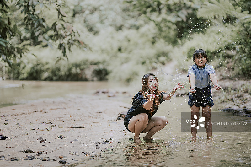 亚洲母亲和女儿在河边玩水图片素材