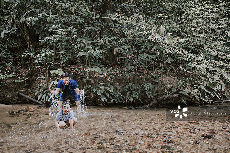 中国父亲在周末休闲时与女儿在河边玩水图片素材