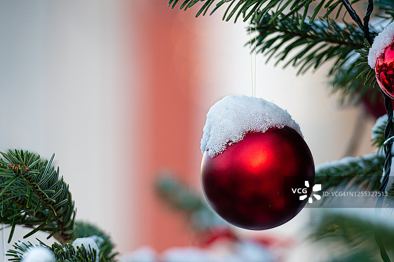 雪 covered 圣诞树上的彩色装饰品图片素材