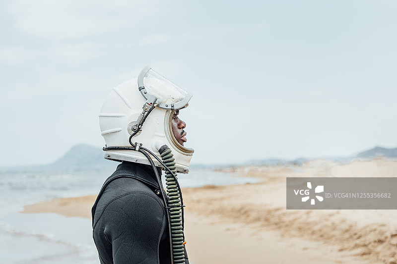 戴着宇航员头盔，直视前方的男人侧面照图片素材