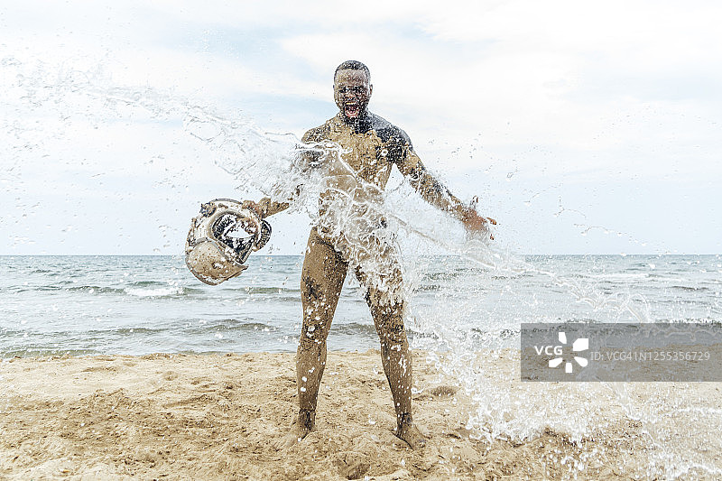 宇航员在海滩上手拿头盔图片素材