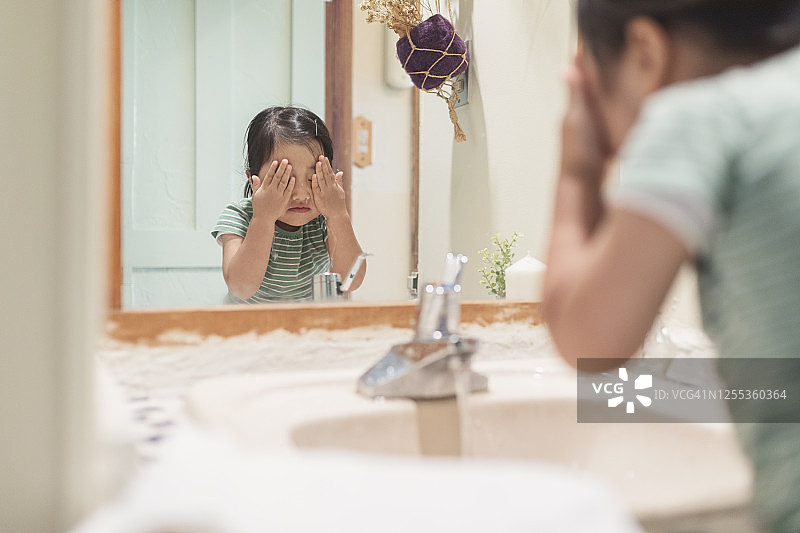 女孩在家里的实验室里洗脸图片素材