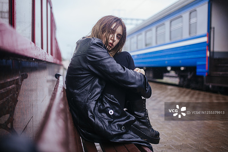 白俄罗斯明斯克，在雨中等待火车月台上的年轻女子图片素材