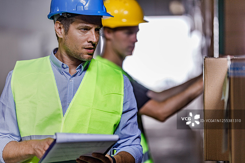 经理在配送仓库中检查清单图片素材