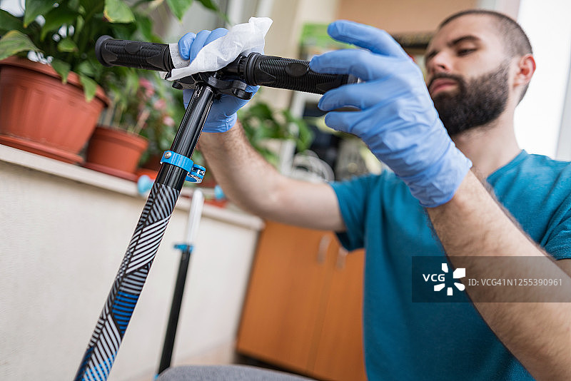 男人消毒他的滑板车图片素材