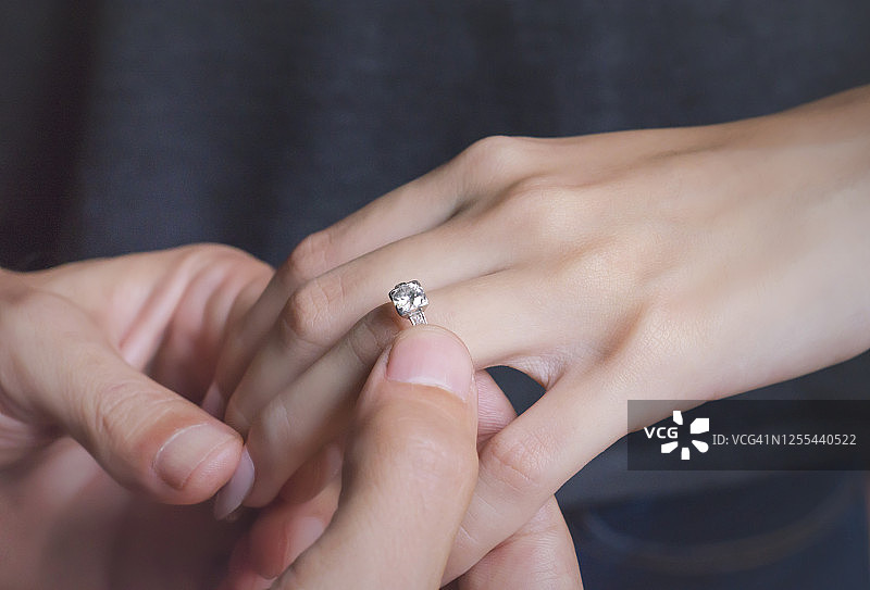 男人为女友戴上订婚戒指图片素材