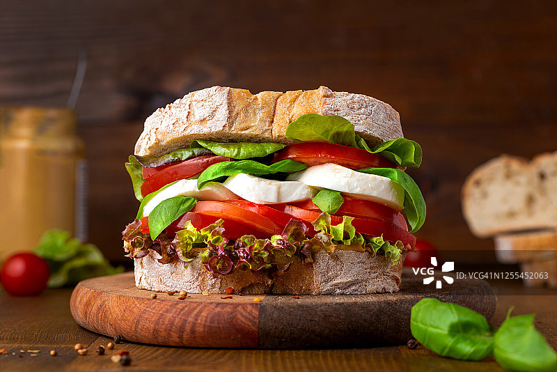 美味的恰巴塔三明治，配马苏里拉奶酪、番茄、罗勒和生菜图片素材
